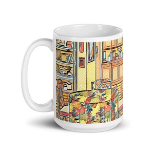 May include: White ceramic mug with a colorful illustration of a kitchen interior. The illustration features a table with a tropical print tablecloth, a chair, and a bookshelf filled with various items.