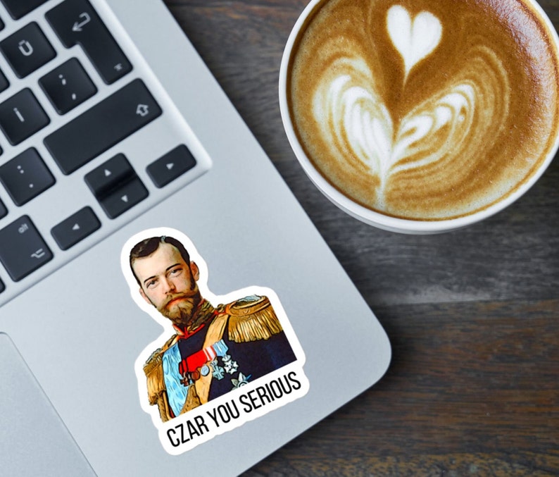 May include: A sticker featuring a portrait of a man in a military uniform with the text "CZAR YOU SERIOUS" printed below. The sticker is on a laptop computer.