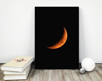 May include: A crescent moon in a dark night sky, with a bright orange glow.