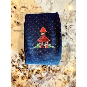 May include: A navy blue tie with a repeating pattern of small red dots. The tie features a detailed illustration of a red schoolhouse with a bird on top, set against a green landscape.