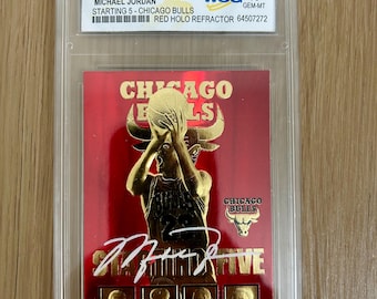 May include: A graded trading card of Michael Jordan, a basketball player for the Chicago Bulls, in a red, gold, and white color scheme. The card is labeled "1996 Skybox NBA Hoops 23KT Gold" and "Starting 5 - Chicago Bulls". The card is graded GEM-MT 10 by the WCG.