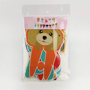 Puede incluir: Una bolsa de pl&aacute;stico que contiene un conjunto de decoraciones de fiesta de tem&aacute;tica canina de colores vivos. Las decoraciones incluyen una pancarta que dice "Feliz cumplea&ntilde;os" y varias formas de perros recortadas.