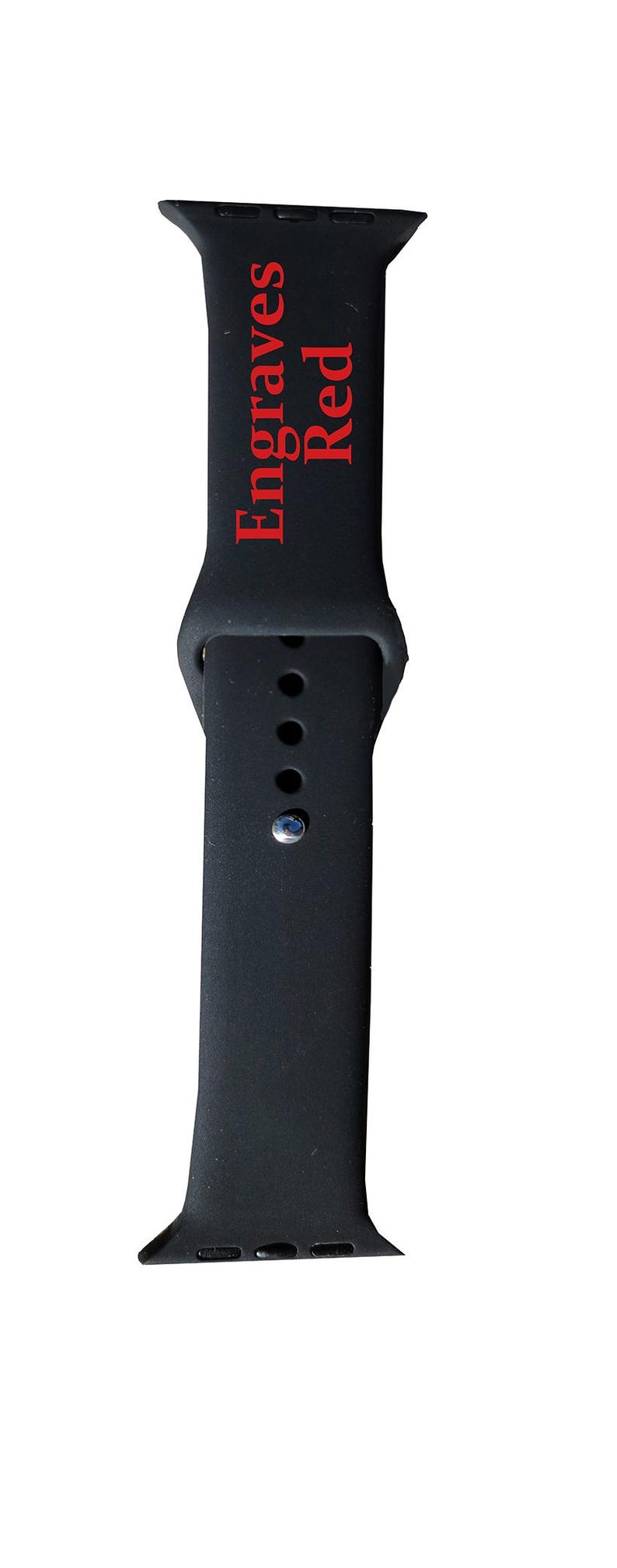 以下が含まれることがあります： 赤い文字で「Engraves Red」と書かれた黒い時計バンド。バンドは柔軟な素材でできており、調整用の穴があります。銀色のピンでバンドを固定します。