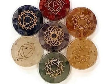 Può includere: Set di sette pietre dei chakra, ognuna con un colore e un simbolo diversi. Le pietre sono disposte in cerchio, con la pietra del chakra radice in basso e la pietra del chakra corona in alto.