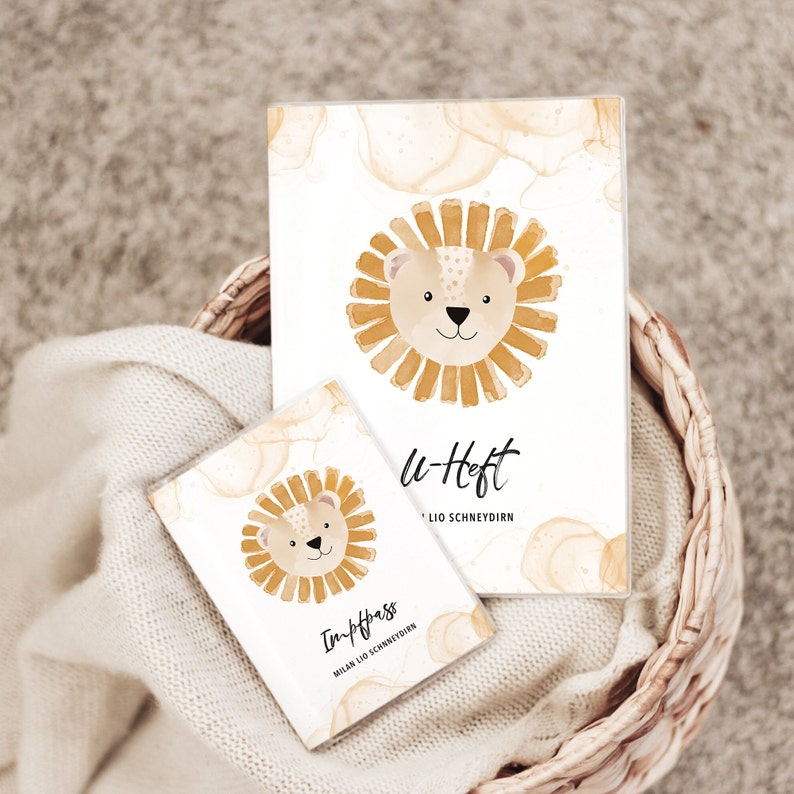 May include: Two small notebooks with a lion illustration on the cover. The larger notebook says "u-Heft" and the smaller notebook says "In-Pass".