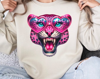 May include: A white sweatshirt with a pink leopard wearing heart-shaped sunglasses. The leopard has a fierce expression and is printed on the front of the sweatshirt.