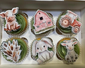 May include: A box of six cupcakes with green icing and farm animal decorations. The decorations include a pig, a red barn, a tractor, wheat, a bunny, and a goat. The cupcakes are in white paper cases.