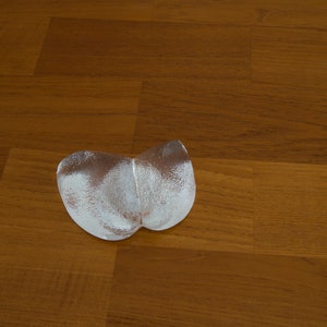 May include: Two silver-colored, heart-shaped ice molds on a wooden surface.