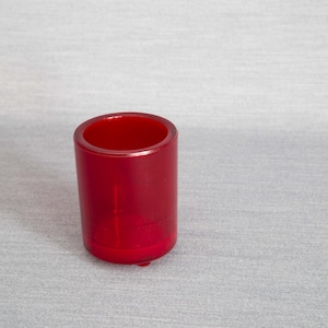 Könnte beinhalten: Ein roter Kerzenhalter aus Kunststoff mit einer glatten, abgerundeten Oberfläche.