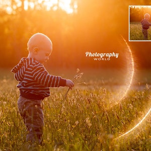 May include: A young child in a striped shirt stands in a field of tall grass, holding a stalk of grass in their hand. The sun is setting in the background, creating a warm glow.