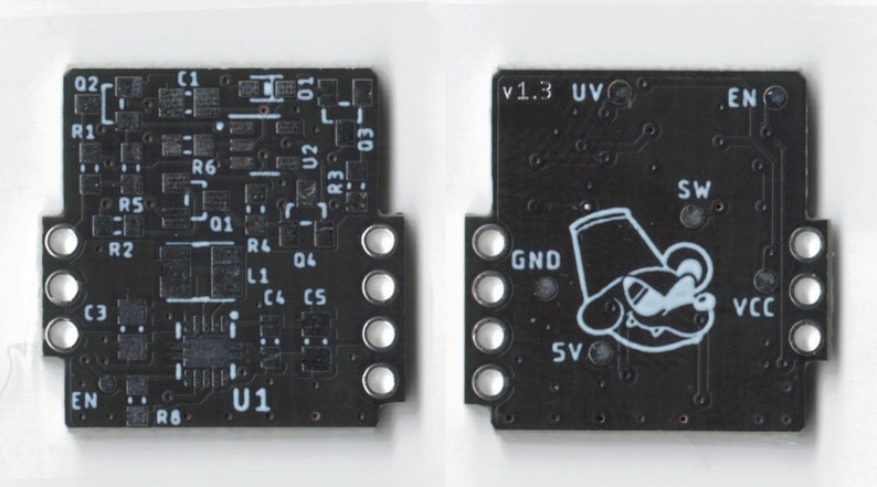 May include: A black circuit board with white text and components. The board has a small cartoon character with a hat and a mustache. The text on the board includes "V1.3 UV", "EN", "GND", "SW", "VCC", and "SV".