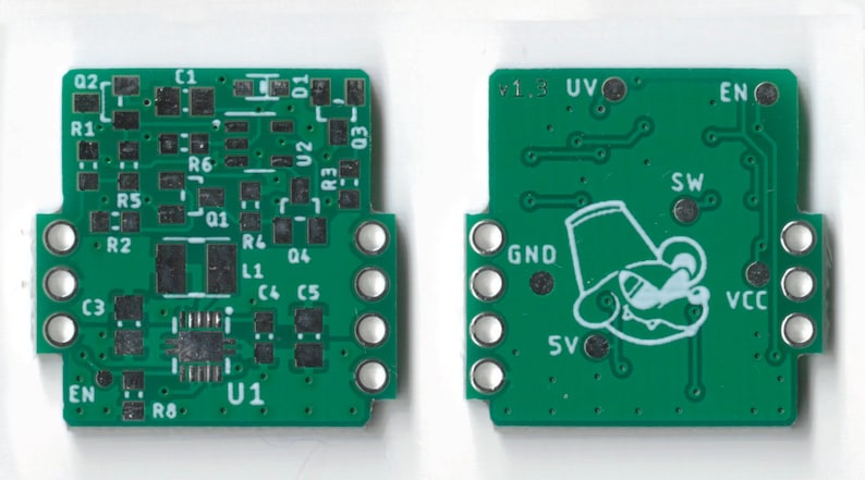 May include: A green circuit board with electronic components, including resistors, capacitors, and an integrated circuit. The board has a white outline of a cartoon mouse wearing a hat and the text "v1.3 UV" and "EN".