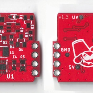 May include: A red circuit board with white text and components. The board has a white logo of a cartoon character wearing a red hat. The text on the board includes "v1.3 UV", "EN", "SW", "GND", "5V", and "VCC".