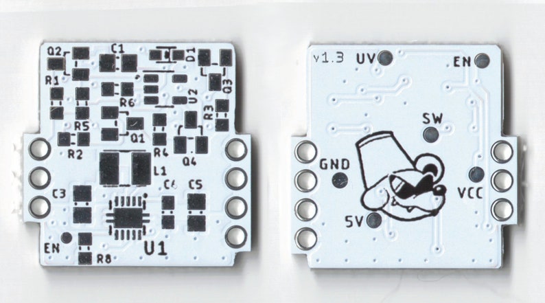 May include: A white circuit board with black components and text, including "v1.3", "UV", "EN", "SW", "GND", "VCC", "5V", and "U1". A cartoon dog with a hat is printed on the board.