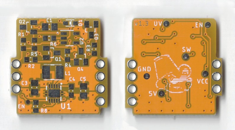 May include: Close-up of an orange printed circuit board with electronic components, including a chip labeled "U1", resistors, capacitors, and a switch labeled "EN". The board has a version number "v1.3" and a label "UV".
