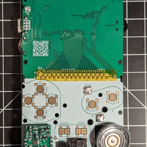 May include: A green circuit board with the text "MGBC-MBL-01" printed on it. The board has a variety of components, including buttons, a speaker, and a chip labeled "U1".