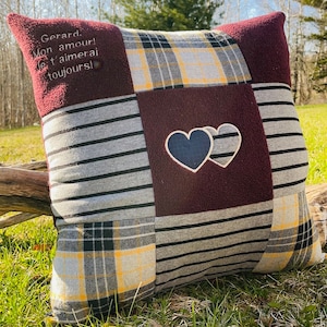 May include: A burgundy, grey, and yellow plaid cushion with a heart design and the text "Gerard. Mon amour! Je t'aimerai toujours!" embroidered on it.