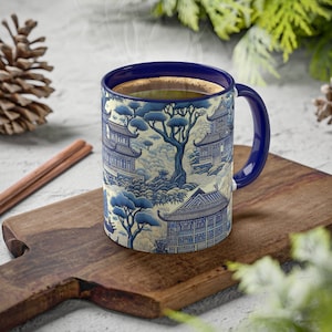 Peut inclure: Une tasse en céramique bleue et blanche avec un motif de pagodes et d'arbres chinois. La tasse est remplie de café et a une anse bleue.