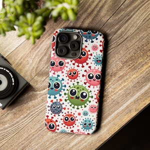 May include: A white phone case with a colorful pattern of cartoon viruses. The case has a camera lens cutout and a white background.