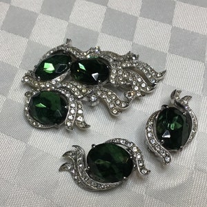 designer Schiaparelli signed. Superb pin and clip-on earrings. Green stones and transparent rhinestones. Circa 1940.