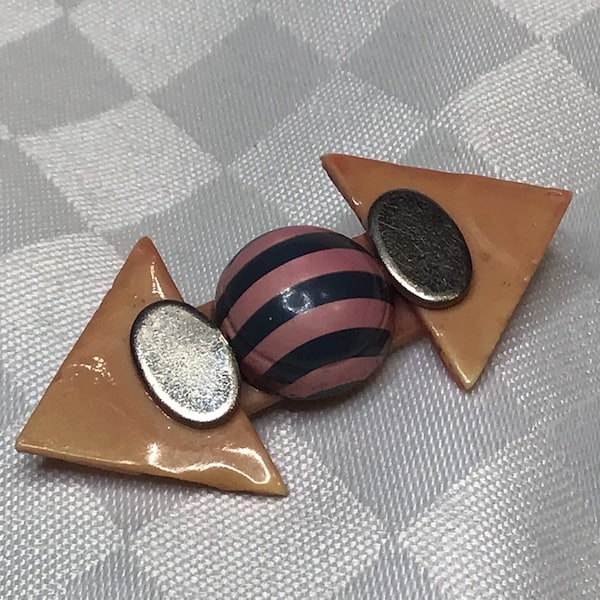 Fun art deco brooch of old painted and varnished plastic, two oval pieces of silver metal and cabochon with pink and gray stripes.