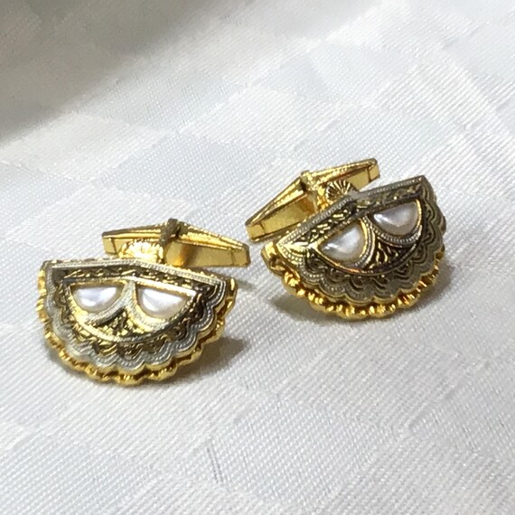 Très beaux boutons de manchettes de Tolède, dorés et noirs ornés de perles d’imitation de forme demi lune. 2 X 2.5 cm.