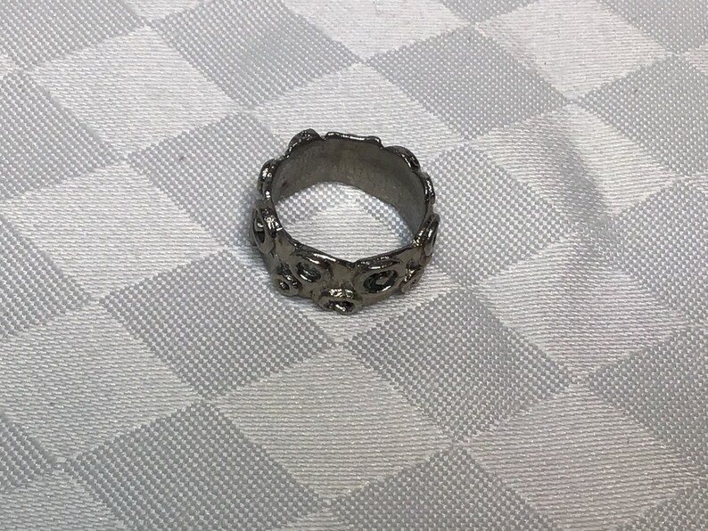 Very pretty brutalist ring of silver brass with abstract drawings of small rounds.