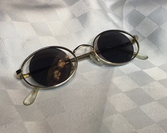 Strange sunglasses with a very particular look, gold-colored metal frames. They should be worn like jewelry.