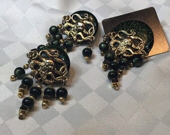 Superb half set brooch and earrings of golden metal with dark green resin washers and Medusa head.