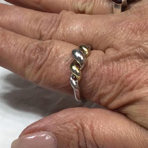 From ELLE. 925 Silver. Beautiful two-tone silver ring, twisted at the front with a Ruby inside. 9 US