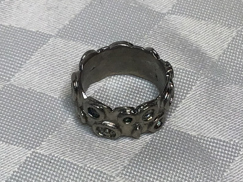 Very pretty brutalist ring of silver brass with abstract drawings of small rounds.