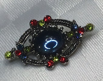 Sublime little silver brooch with glass rhinestones in red, blue and green colors with translucent blue glass cabochon.