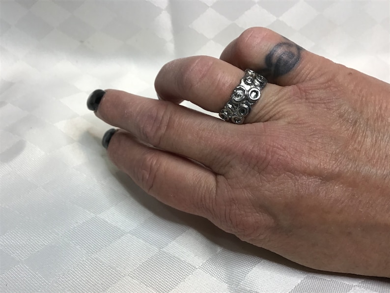 Very pretty brutalist ring of silver brass with abstract drawings of small rounds.