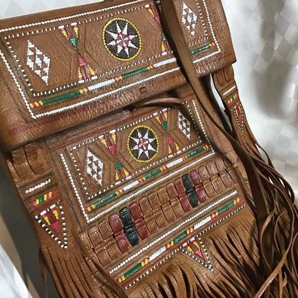 Magnifique sac de cuir tan de style Marocain Berbère avec multiples franges au bas et sortant du rabat, brodé et coloré sur le devant.