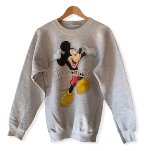 May include: A gray sweatshirt with a vintage Mickey Mouse graphic and the word "Mickey" printed in silver lettering.