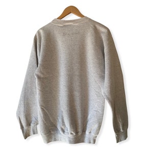 May include: A gray sweatshirt with the text "Live Inspired" printed on the back.