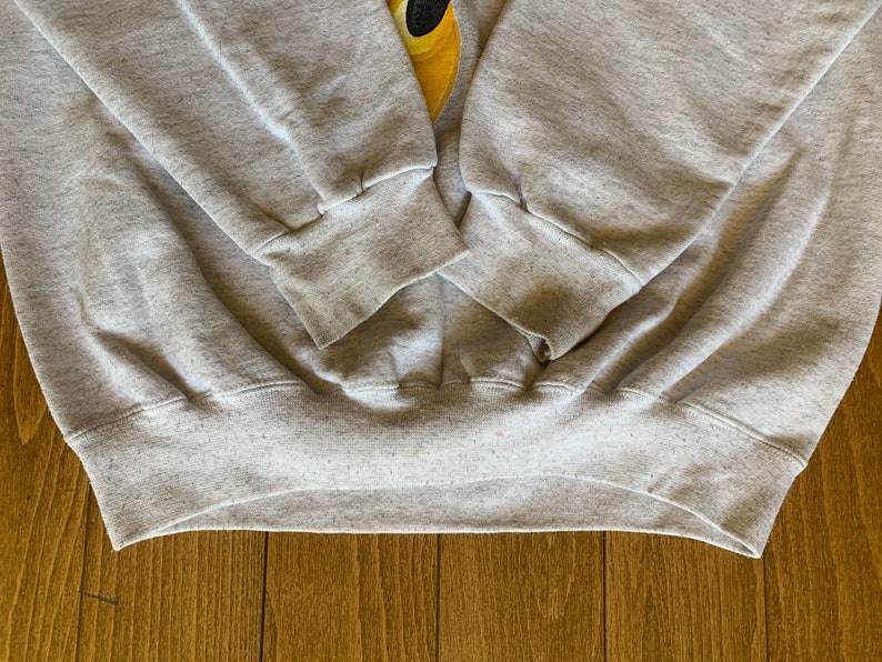 May include: Gray sweatshirt with ribbed cuffs and waistband. The sweatshirt is made of a soft, comfortable material.