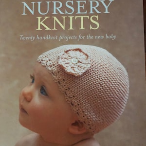 May include: A book titled "Natural Nursery Knits" with a pink knitted baby hat on the cover. The book features twenty handknit projects for the new baby.