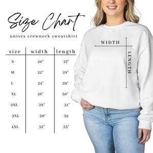 May include: A white unisex crewneck sweatshirt with a size chart. The size chart shows the width and length measurements in inches for sizes S to 4XL. The model is wearing the sweatshirt and blue jeans.