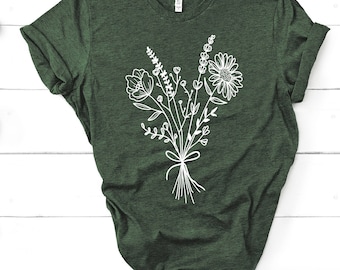 May include: A dark green t-shirt with a white floral design. The design features a bouquet of flowers with stems tied together with a ribbon.