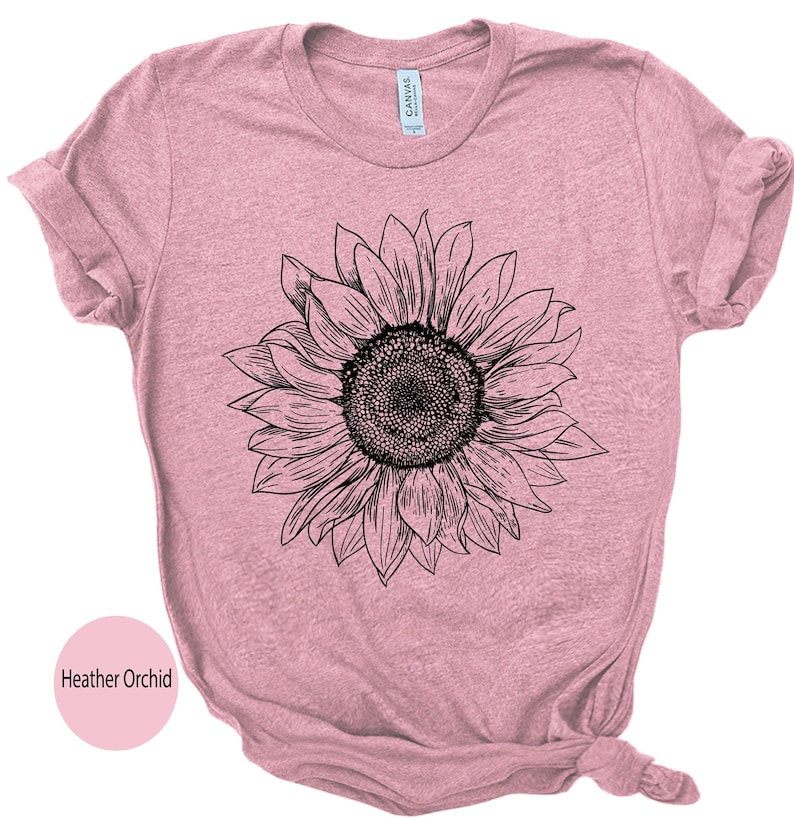 May include: A heather orchid colored t-shirt with a black and white line drawing of a sunflower.