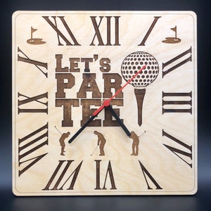 Puede incluir: Un reloj de madera con números romanos y un diseño de bola de golf. La esfera del reloj dice "Let's Par Tee".