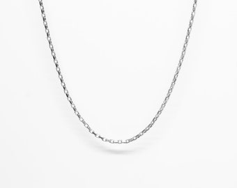 May include: A silver-colored chain necklace with a delicate, rectangular link design. The necklace hangs against a white background, showcasing its simple elegance. This piece of jewelry is suitable for everyday wear.