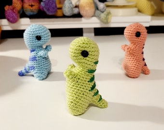 May include: Three crocheted dinosaur toys. One is light blue, one is light green, and one is light pink.