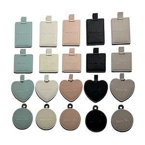 May include: Assortment of 18 different shaped and colored keychains with the word "GLOWTEN" embossed on each. The keychains are in the shapes of squares, hearts, and circles.