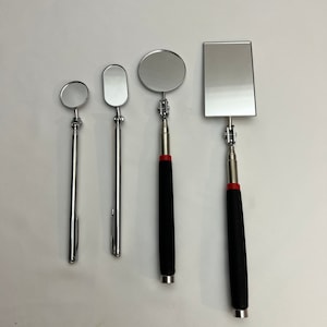 May include: Four different sizes of telescoping inspection mirrors with a magnetic tip. The mirrors have a silver finish and black handles. The largest mirror has a rectangular shape, while the other three are round or oval.