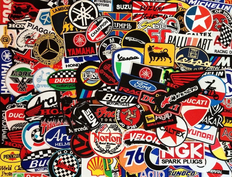 May include: A collection of colorful embroidered patches featuring various motorcycle and automotive brands, including Yamaha, Honda, Ducati, Suzuki, and Vespa. The patches are arranged in a random pattern and are all different sizes and shapes.