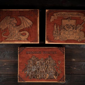 May include: Three wooden plaques with intricate laser-cut designs. One features a dragon, another a treasure chest, and the third a group of figures. Each plaque has the words "Dungeon Master" or "Dungeon Battles" engraved on it.