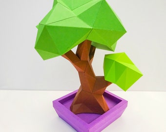 May include: A green origami tree with a brown trunk and a purple square pot. The tree is made of paper and has a geometric design.