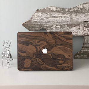 May include: A brown wood laptop case with a white Apple logo. The case has a wood grain pattern.
